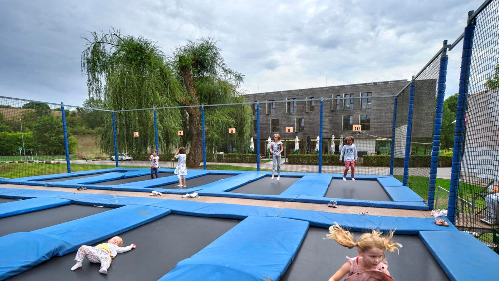 Kids bouncing on the outdoor trampoline park at the Echternach youth hostel