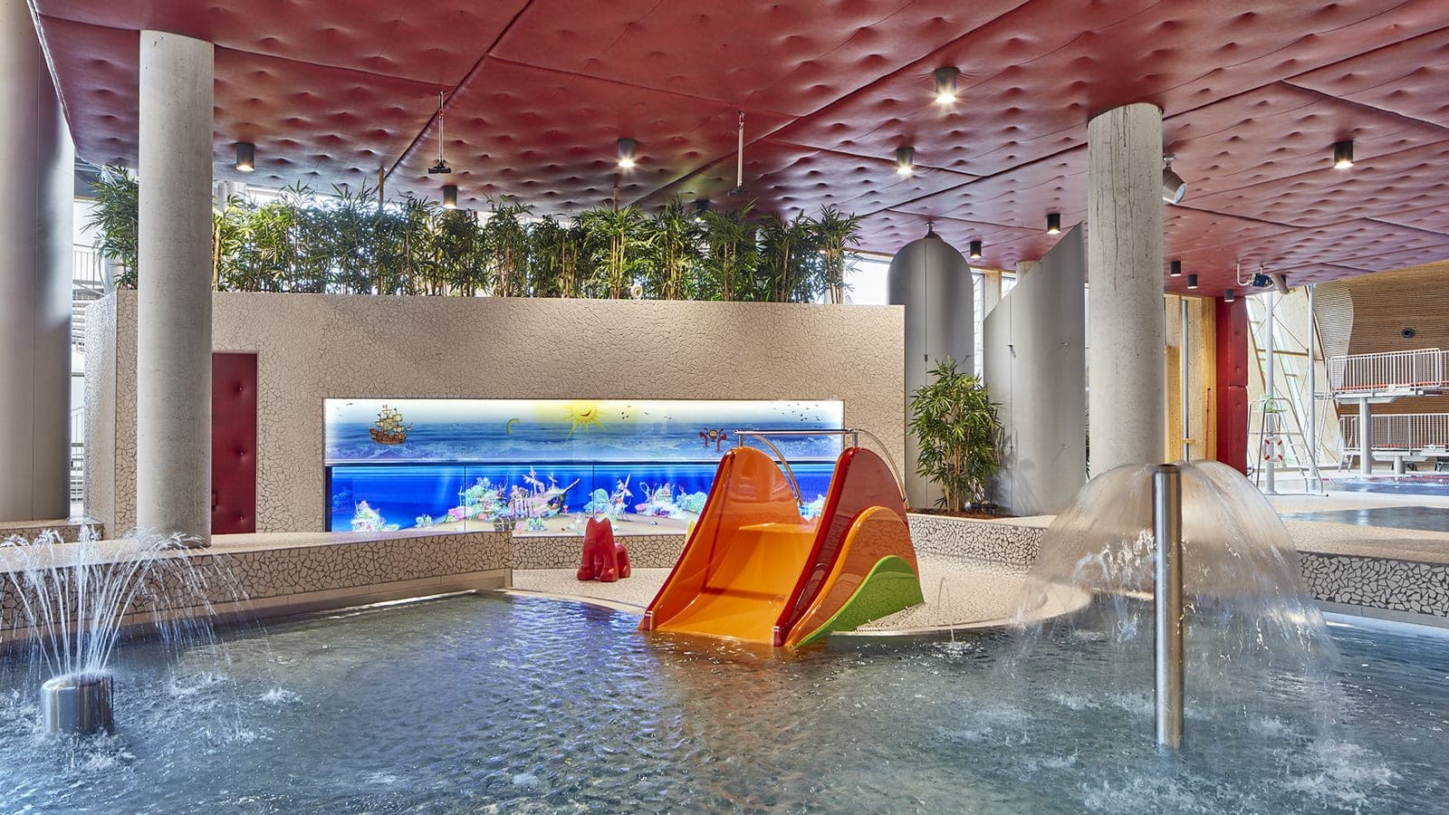Kids' indoor pool at Les Thermes with the signature orange slide and floating play balls.