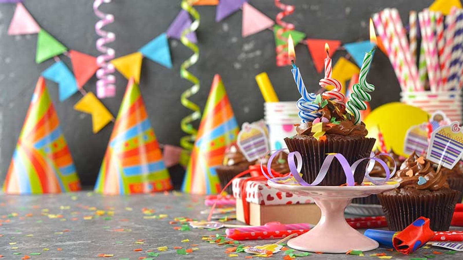 Birthday cupcake and party hats on a Strike Bowling table